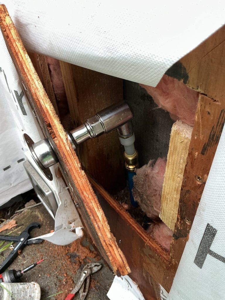 Inside the wall cavity, the new frost-free hose bibb connected to the home's PEX water supply line