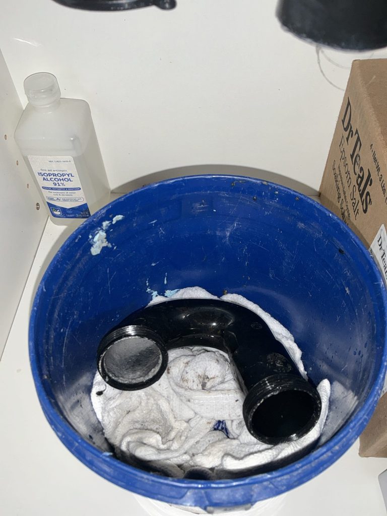 The removed bathroom sink P-trap resting in a bucket during the Kirkland drain cleaning