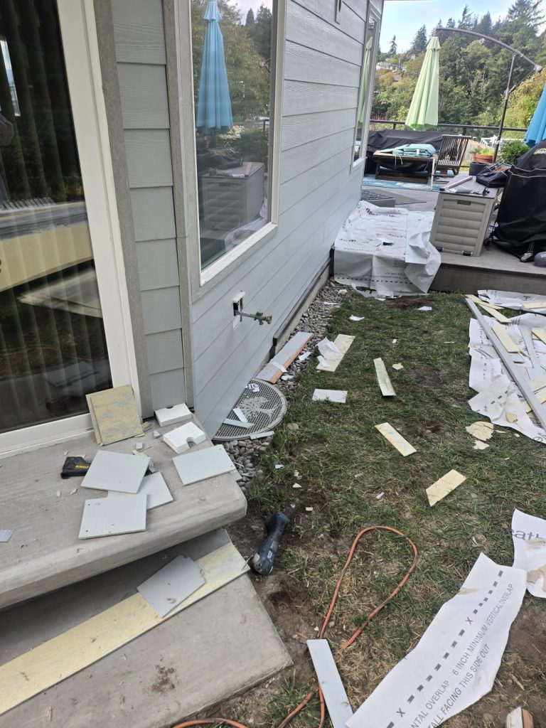 Siding pulled back to the weather barrier around the old hose bibb at a Burien, WA home before the frost-free replacement