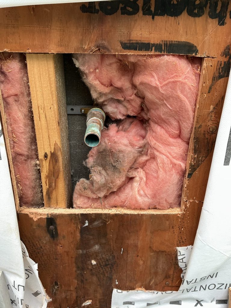 Exterior wall opened up to expose the old copper supply stub after the original hose bibb was removed