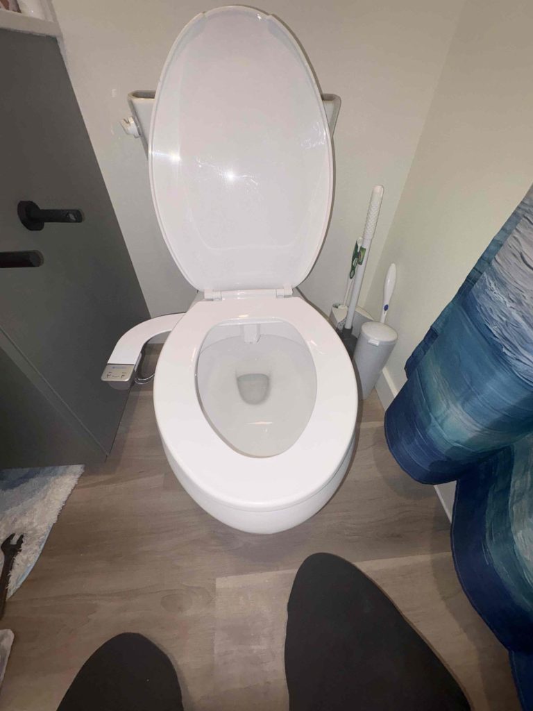 Toilet with the repositioned bidet seat back in service and leak-free in a Seattle, WA bathroom